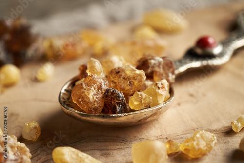 Frankincense resin crystals on a metal spoon on a table