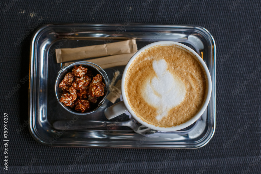 A cup of hot latte on a wooden table in the warm afternoon sun.