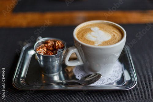 A cup of hot latte on a wooden table in the warm afternoon sun.