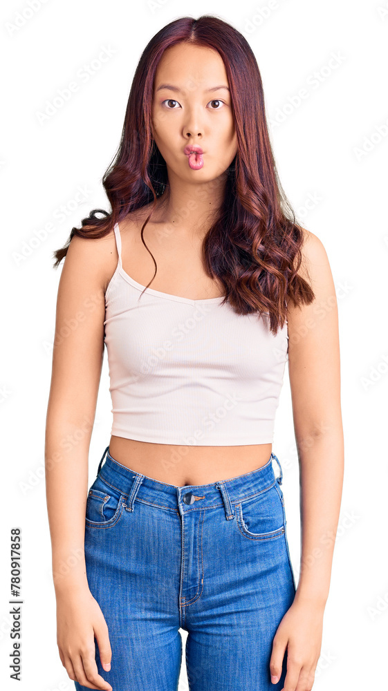 Young beautiful chinese girl wearing casual clothes making fish face with lips, crazy and comical gesture. funny expression. Young beautiful chinese girl wearing casual clothes making fish face with lips, crazy and comical gesture. funny expression.