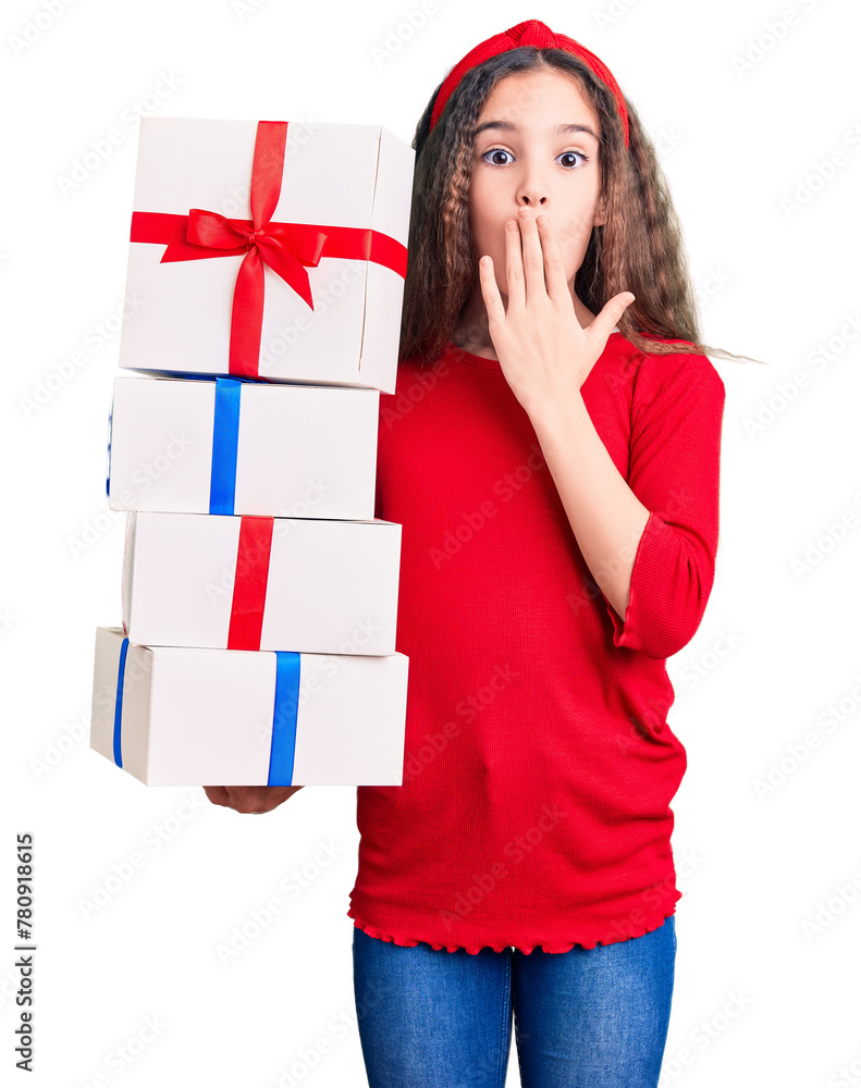 Cute hispanic child girl holding gift covering mouth with hand, shocked and afraid for mistake. surprised expression Cute hispanic child girl holding gift covering mouth with hand, shocked and afraid for mistake. surprised expression