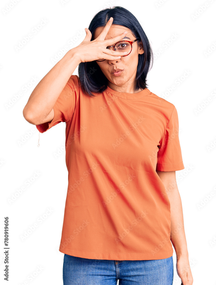 Young beautiful latin woman wearing casual clothes peeking in shock covering face and eyes with hand, looking through fingers with embarrassed expression. Young beautiful latin woman wearing casual clothes peeking in shock covering face and eyes with hand, looking through fingers with embarrassed expression.