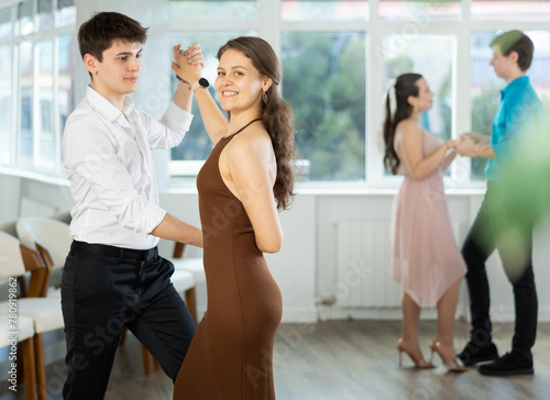 Young man and young woman dance ballroom dance waltz in studio