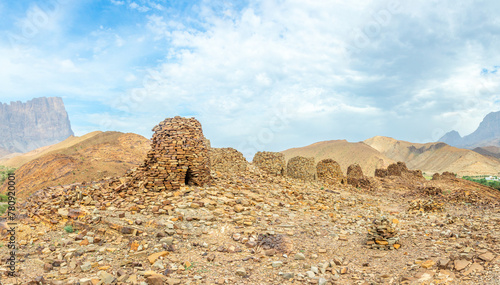 Group of ancient stone beehive tombs with Jebel Misht mountain in the background, archaeological site near al-Ayn, sultanate Oman