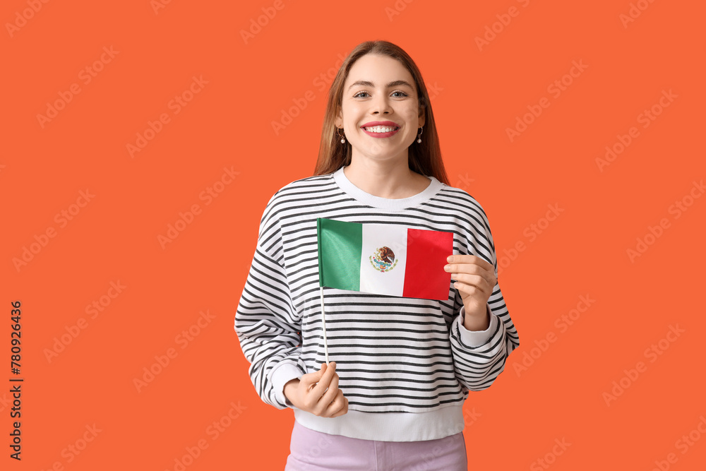 Happy young woman with Mexican flag on orange background Happy young woman with Mexican flag on orange background