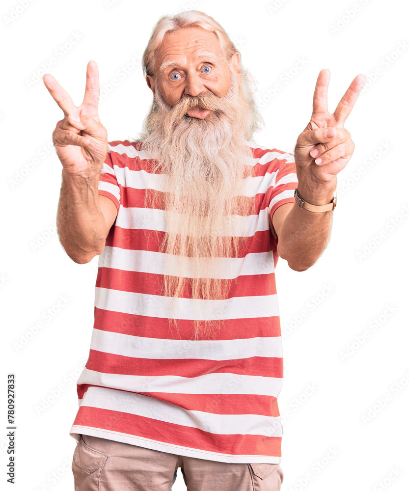 Old senior man with grey hair and long beard wearing striped tshirt smiling with tongue out showing fingers of both hands doing victory sign. number two. Old senior man with grey hair and long beard wearing striped tshirt smiling with tongue out showing fingers of both hands doing victory sign. number two.