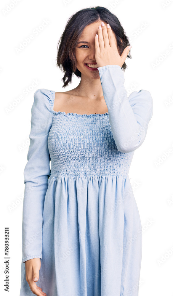 Young beautiful girl wearing casual clothes covering one eye with hand, confident smile on face and surprise emotion. Young beautiful girl wearing casual clothes covering one eye with hand, confident smile on face and surprise emotion.