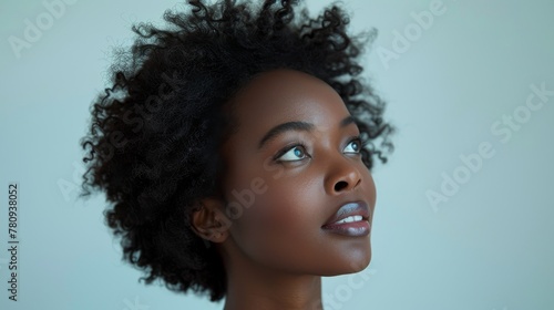 A black businesswoman looks up at a white background in profile