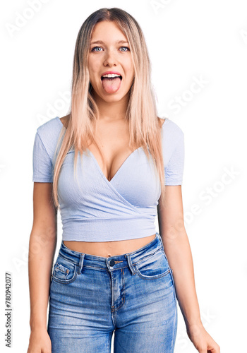 Young beautiful blonde woman wearing casual clothes sticking tongue out happy with funny expression. emotion concept.