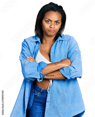 Beautiful hispanic woman wearing casual denim jacket skeptic and nervous, disapproving expression on face with crossed arms. negative person.