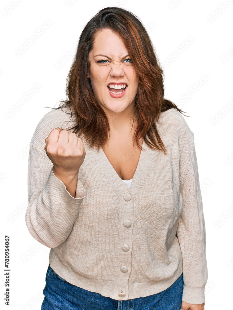 Young plus size woman wearing casual clothes angry and mad raising fist frustrated and furious while shouting with anger. rage and aggressive concept. Young plus size woman wearing casual clothes angry and mad raising fist frustrated and furious while shouting with anger. rage and aggressive concept.
