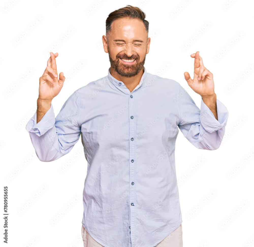 Handsome middle age man wearing business shirt gesturing finger crossed smiling with hope and eyes closed. luck and superstitious concept. Handsome middle age man wearing business shirt gesturing finger crossed smiling with hope and eyes closed. luck and superstitious concept.