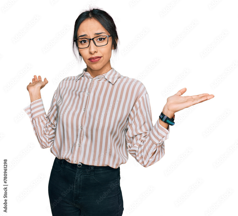 Young hispanic girl wearing casual clothes and glasses clueless and confused expression with arms and hands raised. doubt concept. Young hispanic girl wearing casual clothes and glasses clueless and confused expression with arms and hands raised. doubt concept.