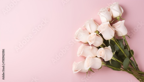 Ramo de rosas sobre fondo rosa con espacio para texto.