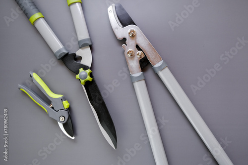 Tools for pruning and trimming plants.Steel Garden tool set on gray background.Secateurs, loppers and hedge trimmers.Garden equipment and tools.Tools for pruning and trimming plants.Plants Pruning