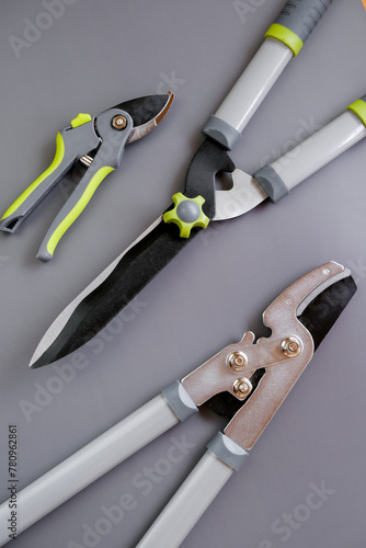 Tools for pruning and trimming plants.Garden tool set on gray background.Secateurs, loppers and hedge trimmers.Garden equipment and tools.Tools for pruning and trimming plants.Plants Pruning Tool. 