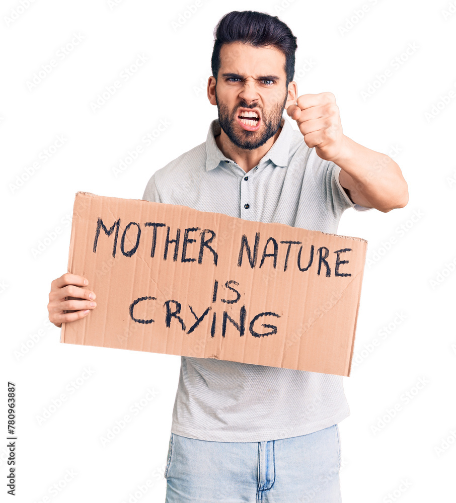 Young handsome man with beard holding mother nature is crying cardboard banner annoyed and frustrated shouting with anger, yelling crazy with anger and hand raised Young handsome man with beard holding mother nature is crying cardboard banner annoyed and frustrated shouting with anger, yelling crazy with anger and hand raised