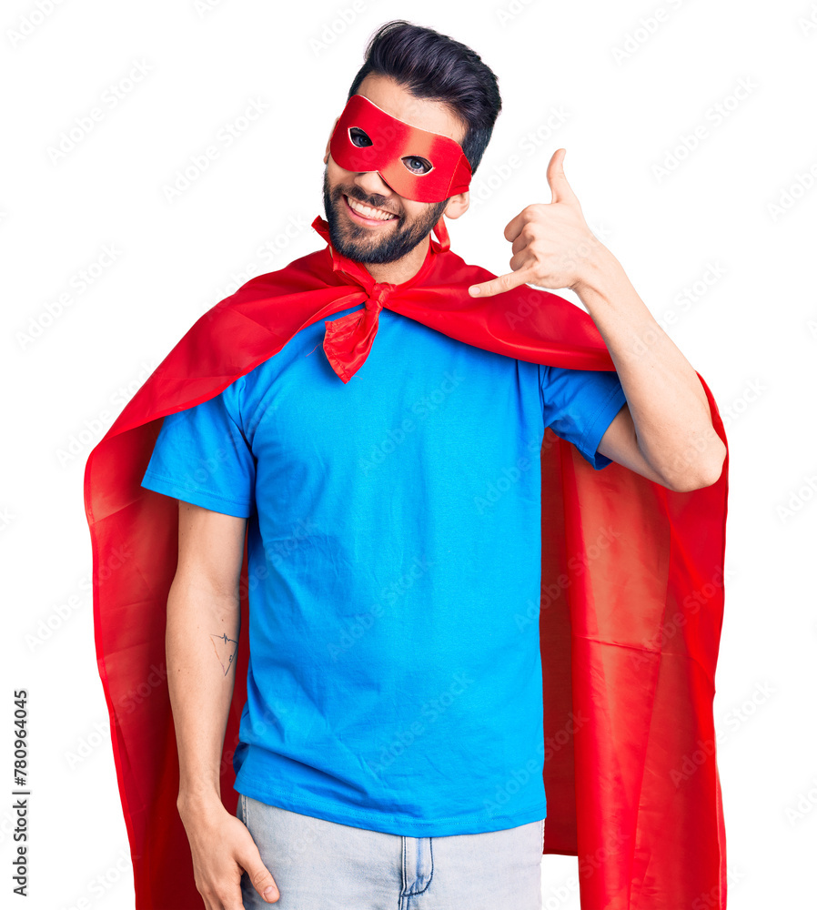 Young handsome man with beard wearing super hero costume smiling doing phone gesture with hand and fingers like talking on the telephone. communicating concepts. Young handsome man with beard wearing super hero costume smiling doing phone gesture with hand and fingers like talking on the telephone. communicating concepts.