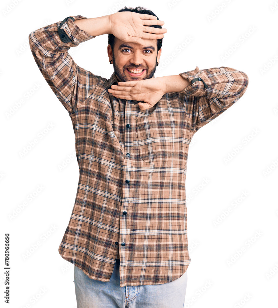 Young hispanic man wearing casual clothes smiling cheerful playing peek a boo with hands showing face. surprised and exited Young hispanic man wearing casual clothes smiling cheerful playing peek a boo with hands showing face. surprised and exited