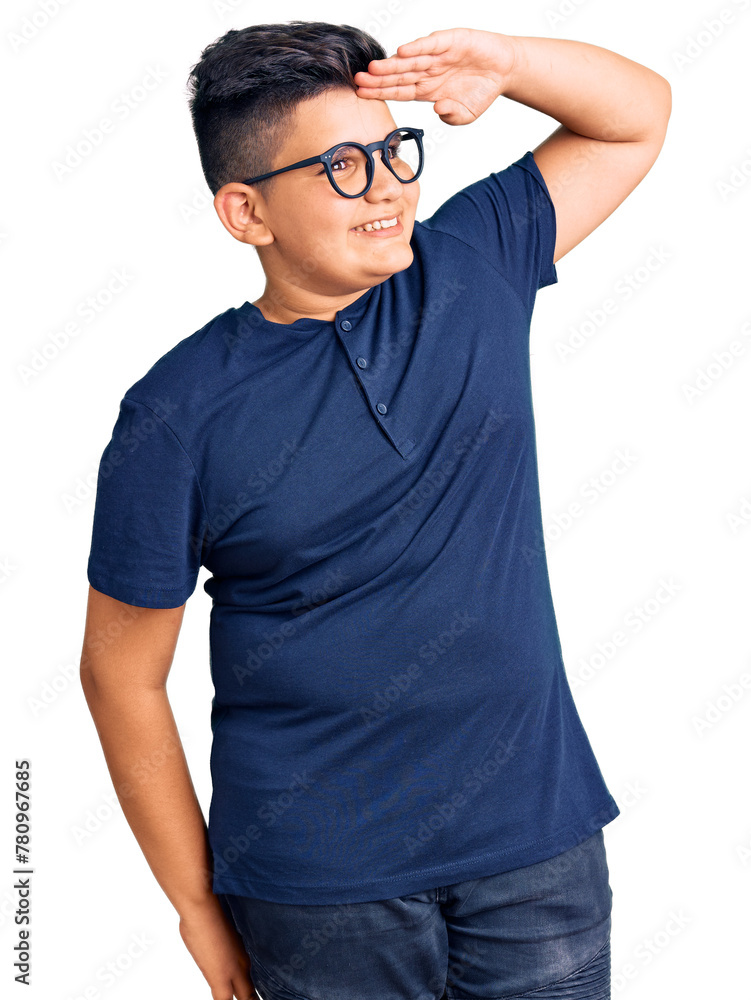 Fototapeta premium Little boy kid wearing casual clothes and glasses very happy and smiling looking far away with hand over head. searching concept.