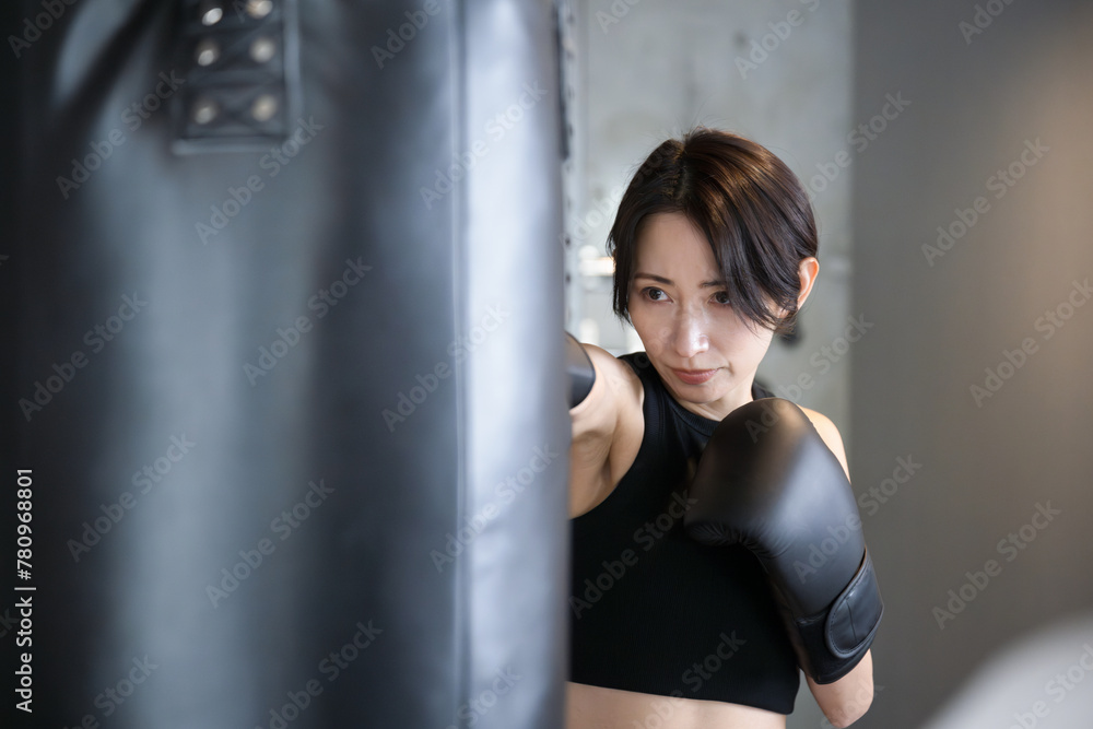 Frontal close-up of cool handsome boxer woman punching at gym boxing and boxercise
