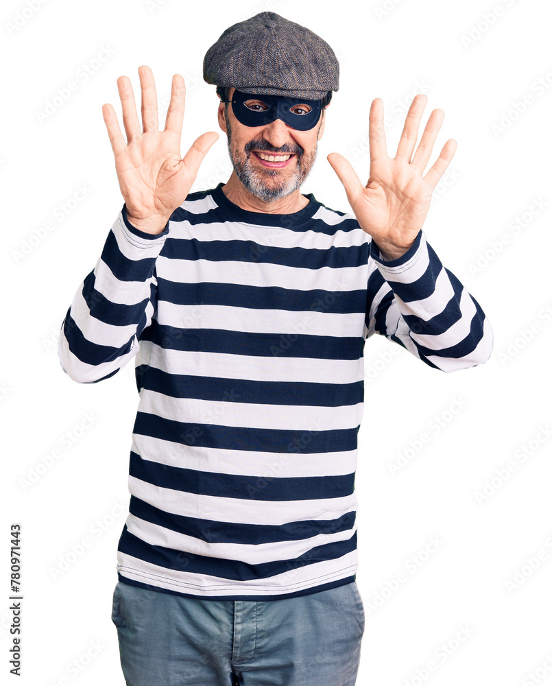 Naklejka premium Middle age handsome man wearing burglar mask showing and pointing up with fingers number ten while smiling confident and happy.