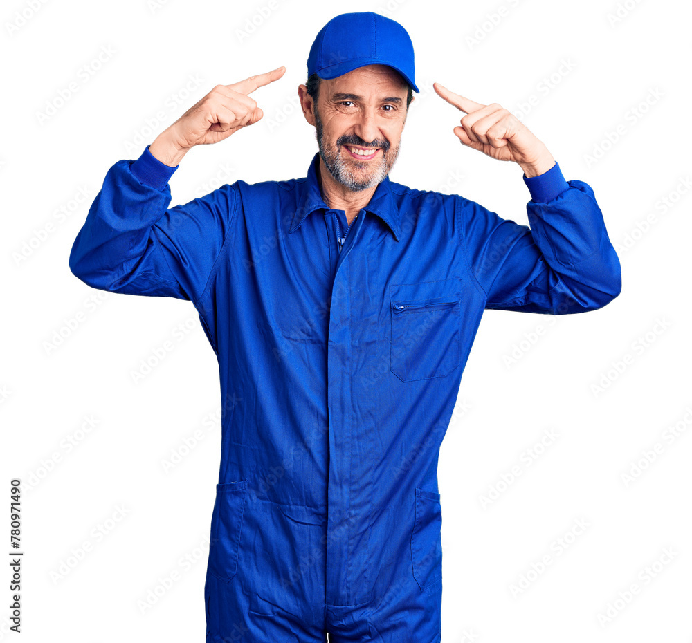 Middle age handsome man wearing mechanic uniform smiling pointing to head with both hands finger, great idea or thought, good memory Middle age handsome man wearing mechanic uniform smiling pointing to head with both hands finger, great idea or thought, good memory