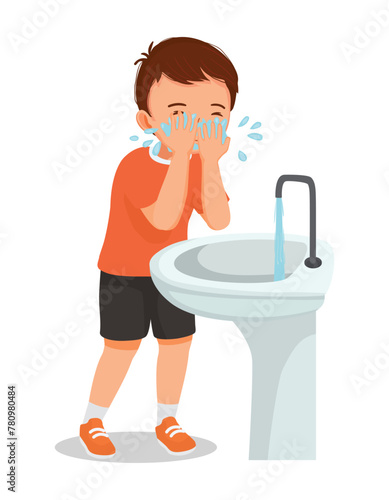 Cute little boy washing face in the sink in the morning
