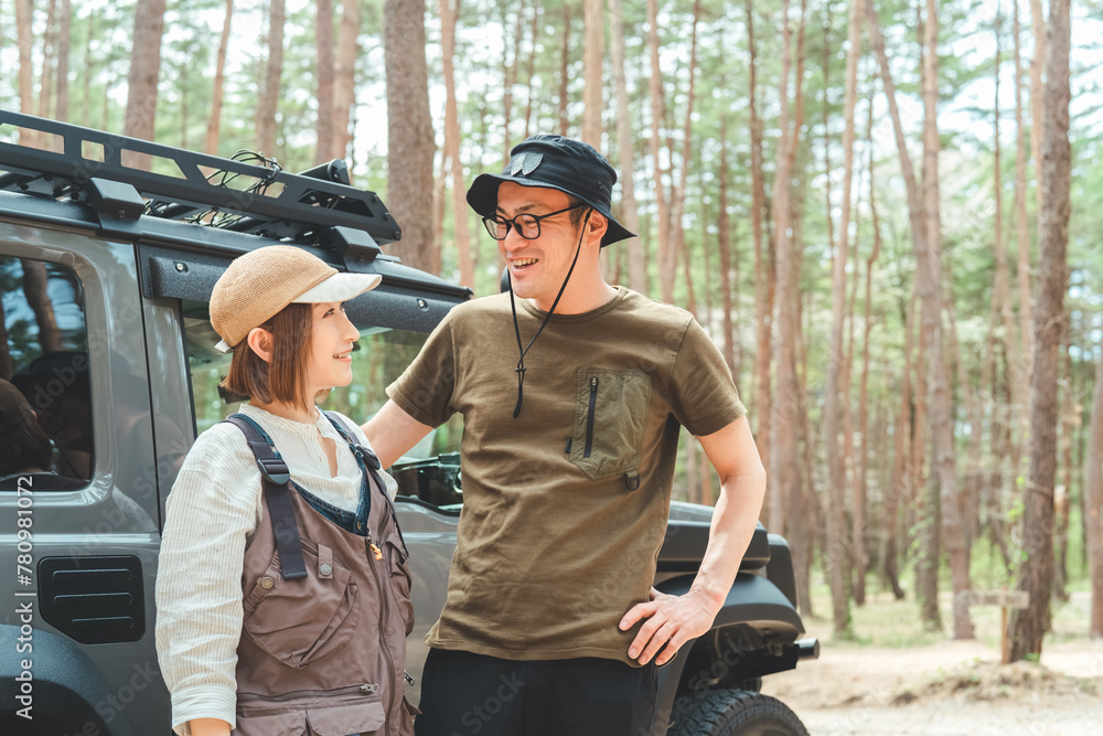 Fototapeta premium RV車・SUV・自動車で旅行・ドライブ・キャンプするアウトドア好きな夫婦キャンパー（オートキャンプ） 