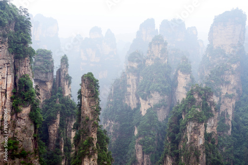 Bild auf Leinwand Sandstone pillars rise above the lush forest of Zhangjiajie National Forest Park in Wulingyuan Scenic Area, China
