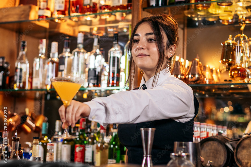 Young female bartender offering a drink