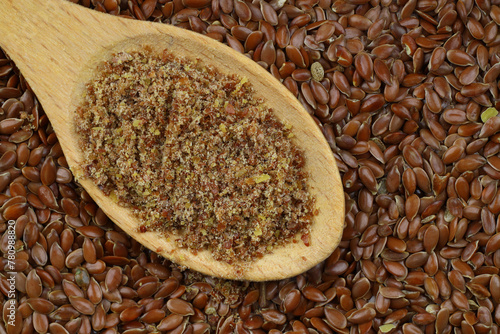 Flax seeds. Flaxseed powder in a wooden spoon. Standing on a Wooden background.