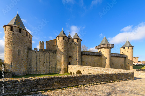 Front view of the bridge and facade of Château Comtal, the large, restored 12th-century hilltop castle, with a museum in medieval walled Carcassonne, France.