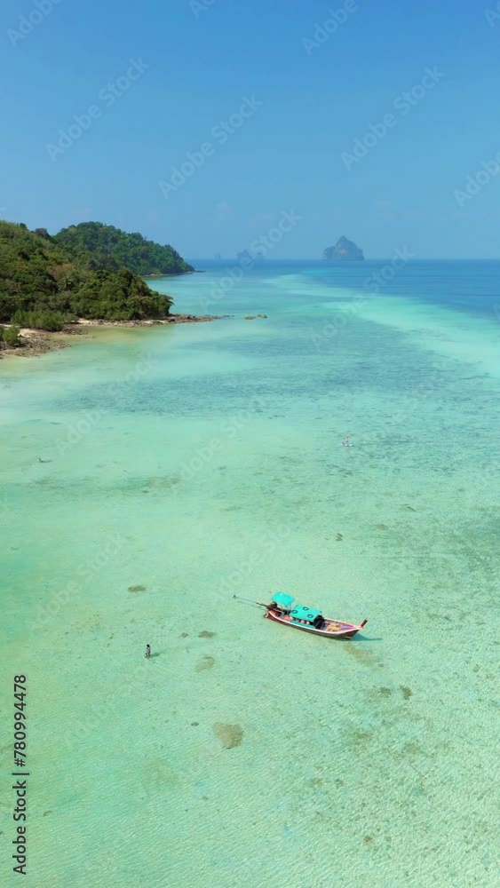 A picturesque tropical beach with a boat floating in the crystalclear water, surrounded by lush natural landscape under the vast blue sky, Koh Kradan, Thailand A picturesque tropical beach with a boat floating in the crystalclear water, surrounded by lush natural landscape under the vast blue sky, Koh Kradan, Thailand