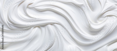 A detailed view of a spiral of white frosting with a small utensil next to it