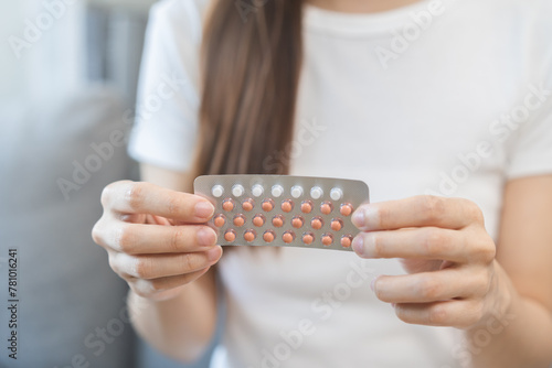 Contraception and pregnancy, menstruation concept, birth control pills asian young woman hand holding hormonal oral contraceptives medicine, take pharmaceutical to prevention, safe virus sex disease. photo