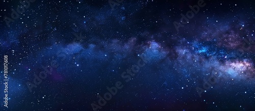 A serene night scene with a dark blue sky filled with numerous stars and a few small white dots twinkling in the distance