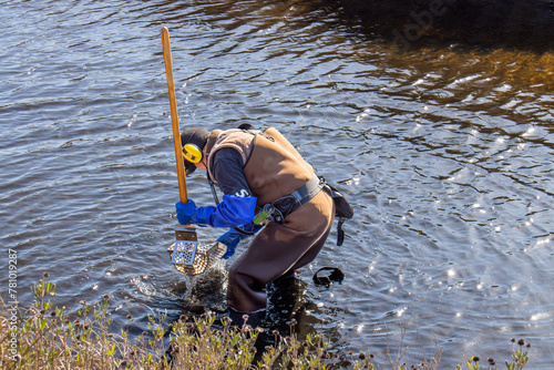 man with metal detector sifting  in water for lost treasure  © Bill Keefrey