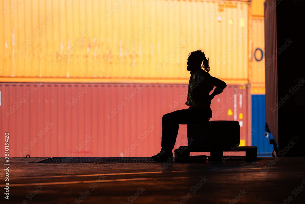 Warehouse worker's back pain from hard work while sitting and relaxing, Silhouette concept Warehouse worker's back pain from hard work while sitting and relaxing, Silhouette concept