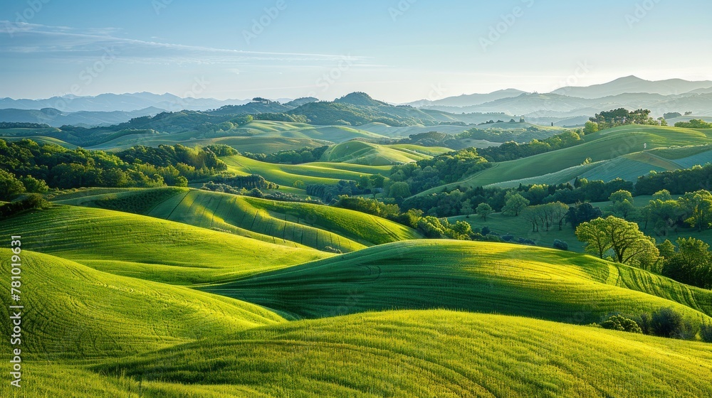 A peaceful countryside scene, with rolling hills blanketed in lush greenery under a clear blue sky.