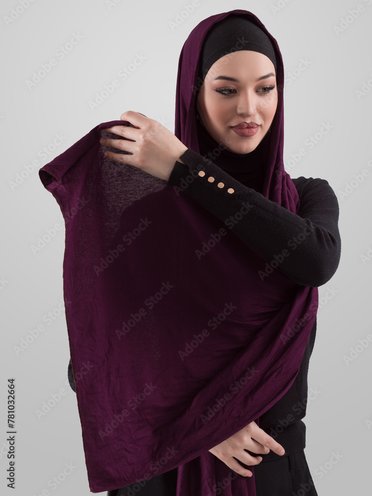 Muslim woman wearing modern stylish wear and hijab isolated on grey background. Diverse people model hijab fashion concept. Muslim woman wearing modern stylish wear and hijab isolated on grey background. Diverse people model hijab fashion concept.