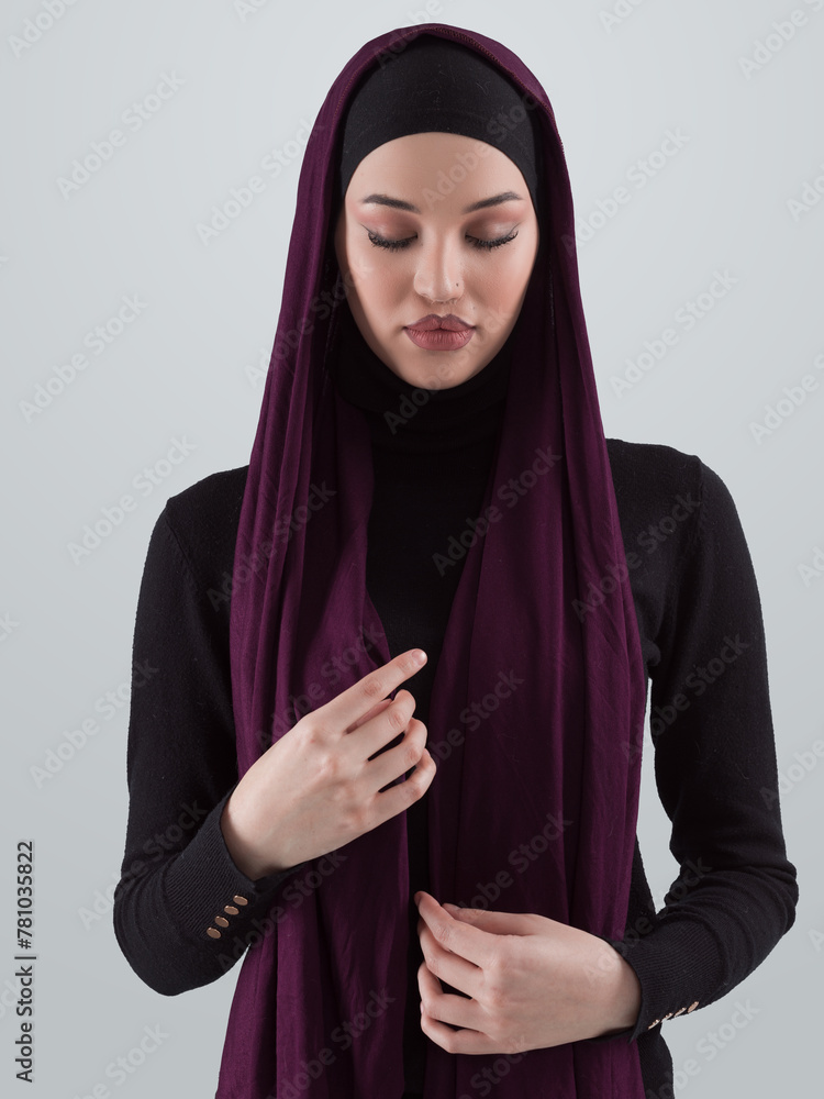 Muslim woman wearing modern stylish wear and hijab isolated on grey background. Diverse people model hijab fashion concept. Muslim woman wearing modern stylish wear and hijab isolated on grey background. Diverse people model hijab fashion concept.