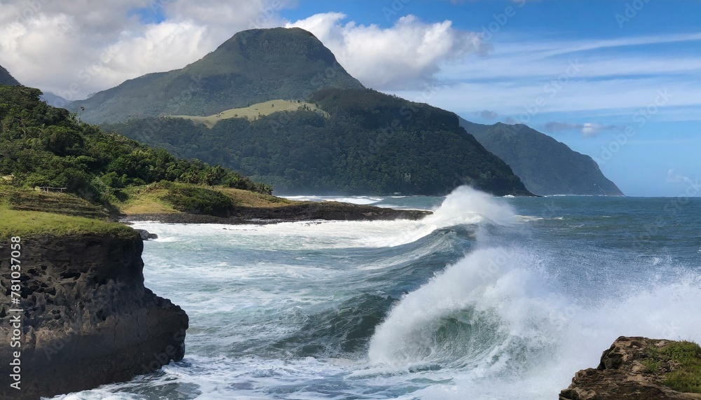 Majestic waves crash against the coastline with lush green mountains in the background, embo