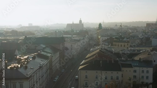 Foggy, autumn morning over Old Town, Kazimierz and Stradom district in Krakow. Visible church towers, colorful, old tenement houses and street with cars and trams. photo