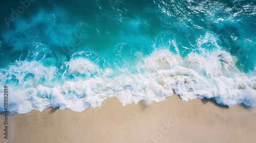 Waves crash on white sand, turquoise sea (top view).