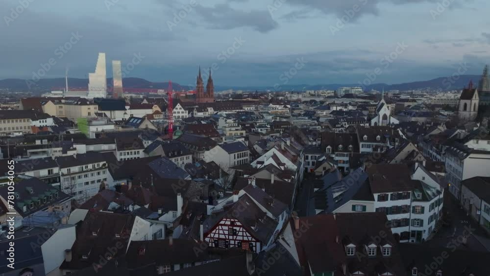 Forwards fly above old town district at dusk. Basel Minster and modern high rise Roche Tower skyscrapers in background. Basel, Switzerland Forwards fly above old town district at dusk. Basel Minster and modern high rise Roche Tower skyscrapers in background. Basel, Switzerland