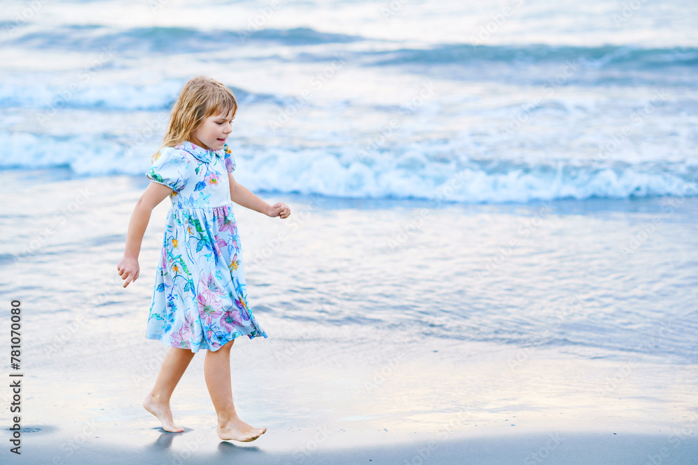 Φωτογραφία Happy Child, Little Preschool Girl in Dress Running And Jumping In The Waves During Summer Vacation On Exotic Tropical Beach by Sunset