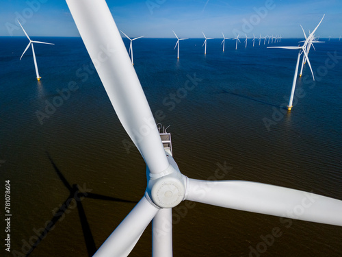 A dynamic group of wind turbines stands tall in the ocean, harnessing the power of the wind to generate renewable energy. windmill turbines green energy in the ocean, energy transition