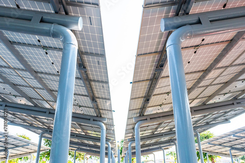 Aerial view of solar panels installed as shade canopy over parking lot with parked cars to generate electricity, photovoltaic technology.