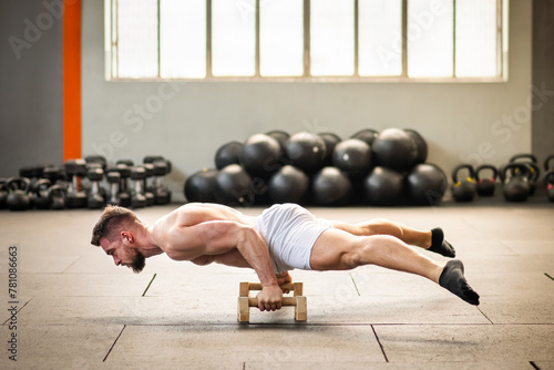 Sportsman doing bent arm straddle planche calisthenics exercise photo